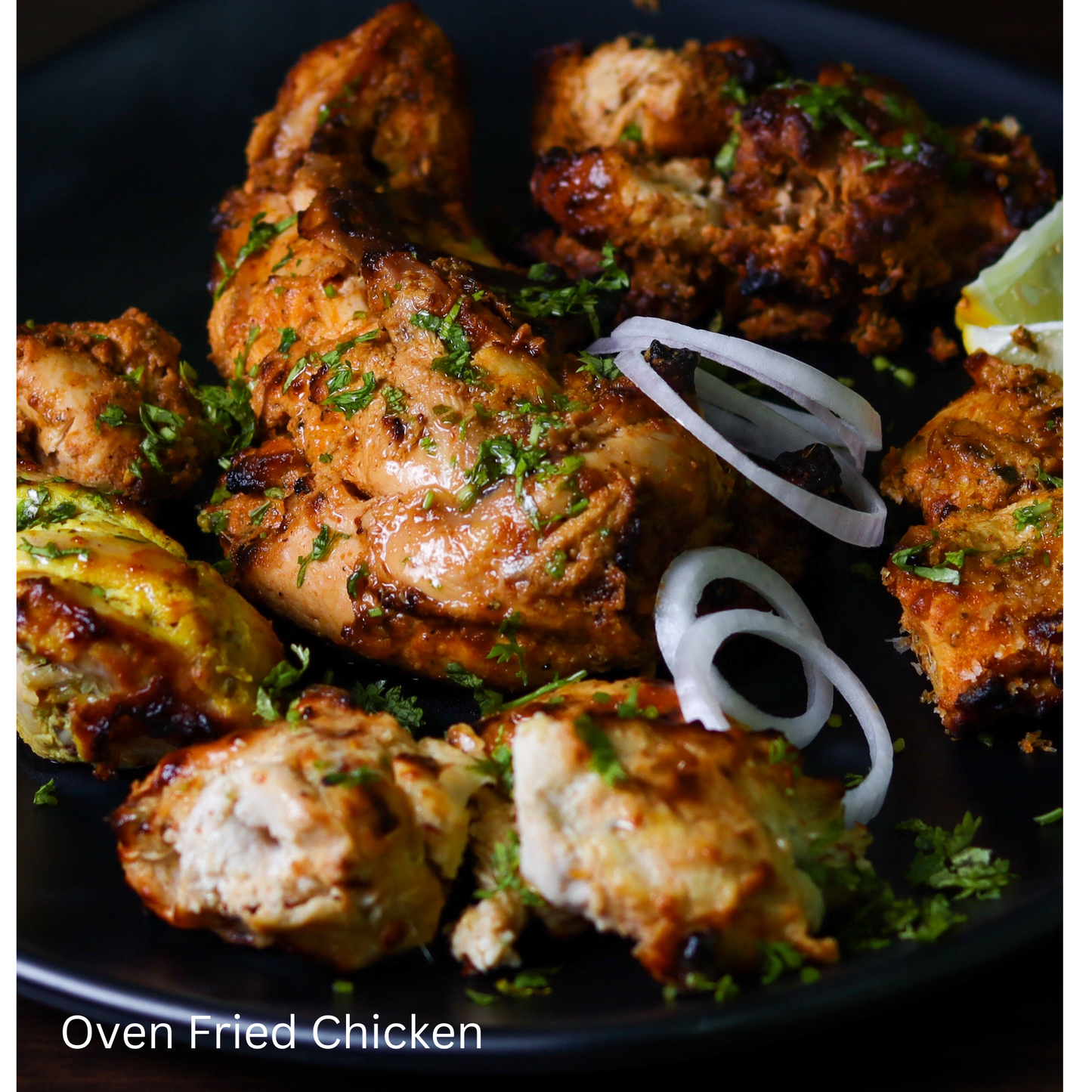 Golden Pieces of Oven Fried Chicken with Herbs on Black Plate